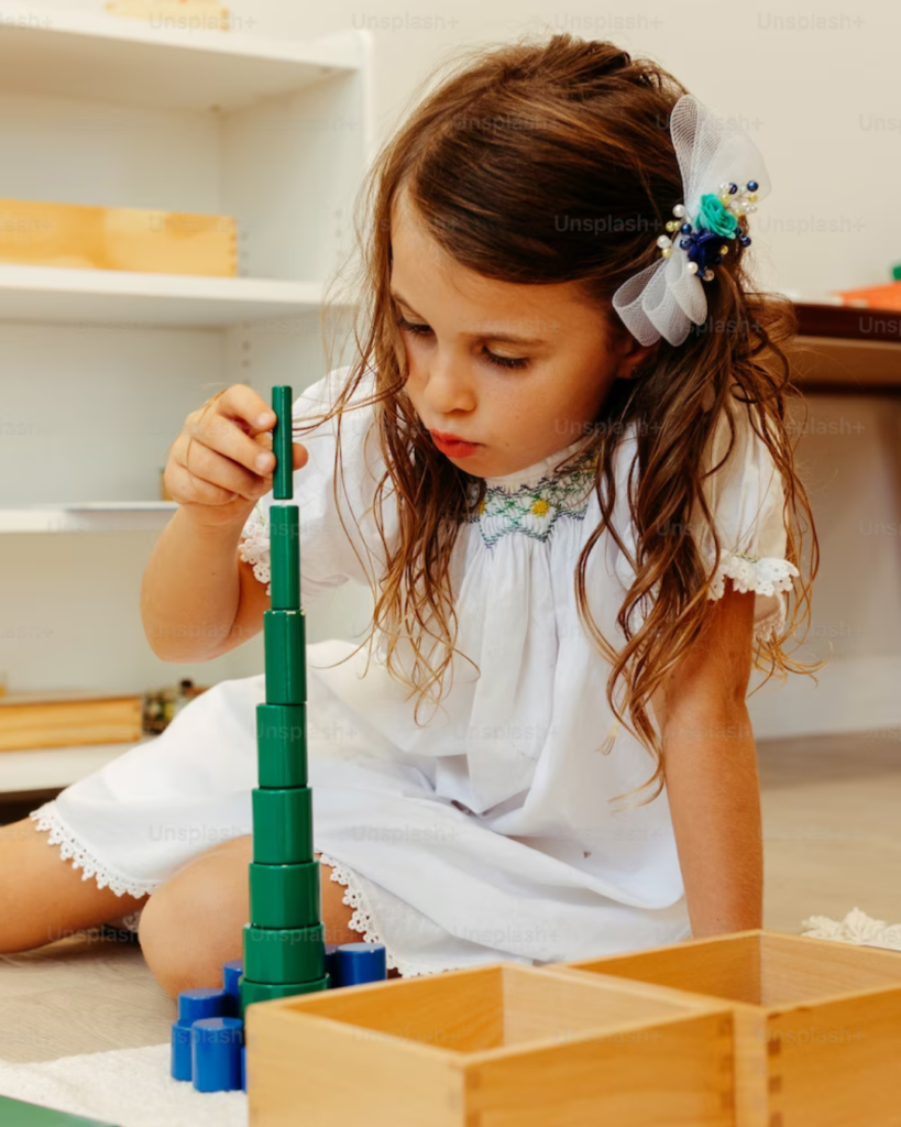 girl in white dress focusing on Montessori work