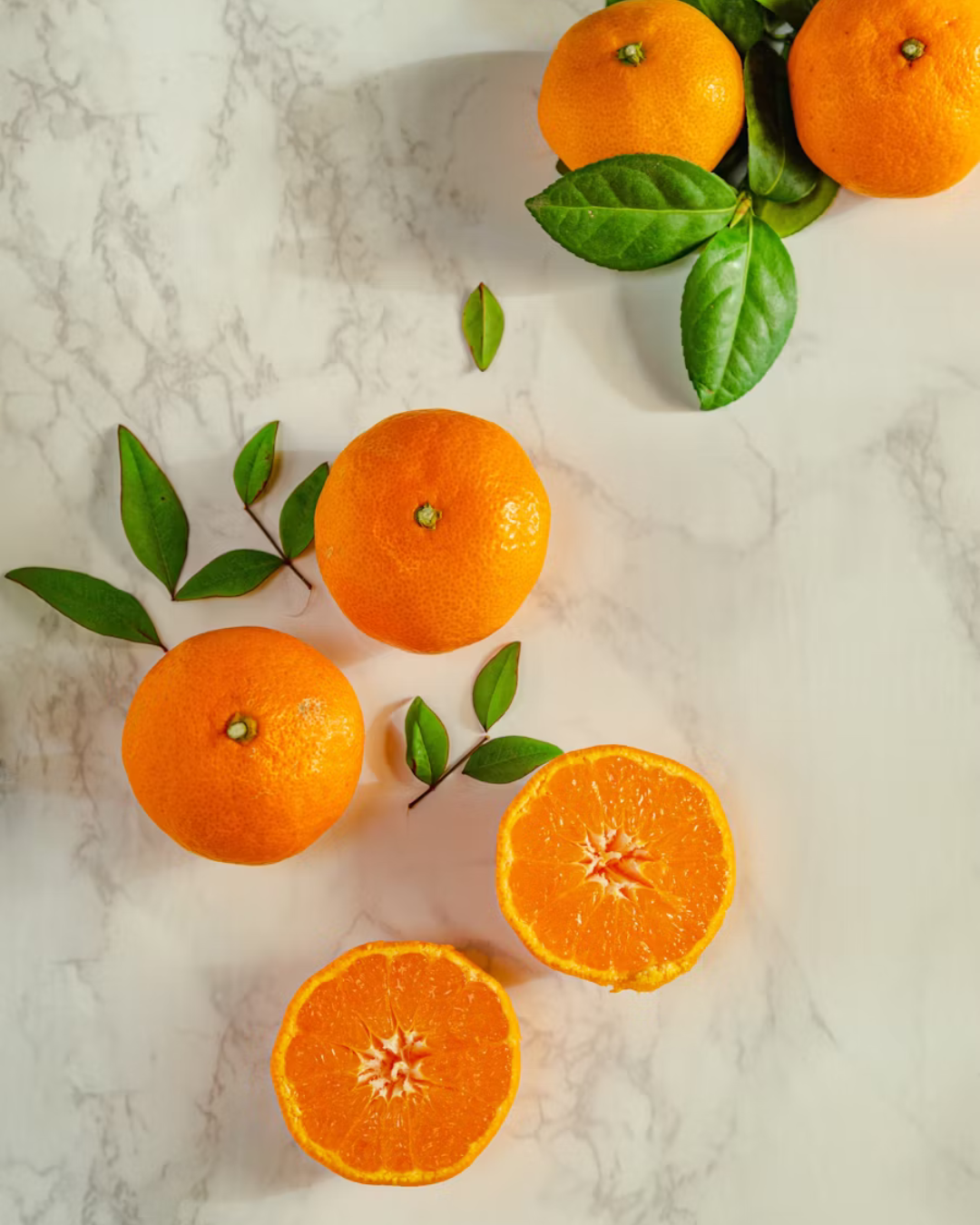 oranges with greenery on marble counters